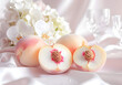 © Obsure - Elegant white peaches on silk fabric with crystal glasses