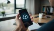 © pimpat - Person Holding Smartphone with Cloud Upload Icon in Modern Office
