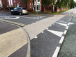 Residential street intersection in Manchester featuring tactile paving and parked car