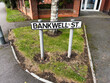 Street sign for Bankwell Street in Manchester surrounded by urban landscape