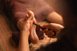 © Parilov - Relaxing thai foot massage with reflexology techniques wooden stick in tranquil spa setting