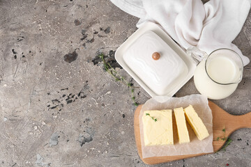 Wall Mural - Composition with fresh butter, ceramic dish and milk on grunge background