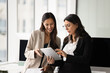 © fizkes - Younger and senior female business colleagues discussing online product