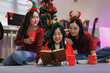 © crizzystudio - Asian friends enjoying christmas party reading storybook
