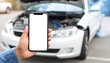 © photostockatinat - A person is holding a smartphone with the car broken down in the background