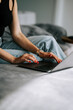 © Darius - Woman working on laptop while sitting on bed in cozy room during daytime