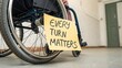 © Tam - Importance of accessibility in everyday spaces highlighted by wheelchair with sign emphasizing every turn matters for inclusion.