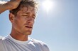 © Netsai - A sweaty and exhausted man with closed eyes, wiping his head under a bright sun, appearing fatigued from physical activity.