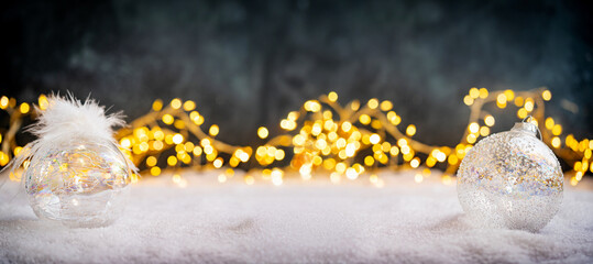 Wall Mural - christmas holiday background with snow, fir tree and decorations with christmas light behind. christ