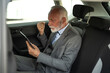 © Zamrznuti tonovi - Senior businessman celebrating success on tablet in car