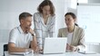 © volha_r - Business people team collaborating and analyzing data on a laptop during a productive meeting in a modern office, fostering teamwork and strategic decision making