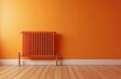 © Viktor - Orange radiator against vibrant orange wall. Metal heating object on wooden floor. Thermostat valves visible. Home interior element provides warmth and heat. Modern design object.