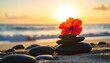 © Mori Deci - A vibrant hibiscus flower rests atop a stack of smooth, dark stones on a sandy beach at sunrise, creating a tranquil and peaceful scene.