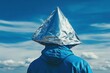 © Chayanan - Man with tinfoil hat viewing chemtrail conspiracy concept under blue sky theory back view