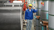 © Wosunan - Industrial worker inspecting inside a large metal tube in a factory