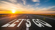 © Celt Studio - Lets go text on cracked asphalt road at sunset, motivational concept of overcoming challenges and obstacles, new beginning on difficult journey to success.