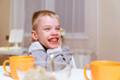 © looking2thesky - A boy with hearing aids and his mother share a warm conversation over tea in their cozy kitchen. A tender moment of family bonding, communication, and inclusive love