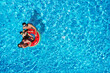 © New Africa - Happy family with inflatable ring in swimming pool, top view. Summer vacation