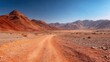 © backup_studio - A red desert dirt road cuts through mountainous terrain under a clear blue sky. Travel and adventure concept with arid landscape.