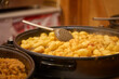 Fried potatoes and traditional stew cooking in large pans at Christmas market. Street food stall at festive fair at night. Concept of winter holidays in European city