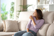 © PheelingsMedia - Satisfied woman enjoying smelling her clothes at home