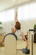 © saltdium - A Vertical image of a graceful pilates student practices a powerful handstand stretch to improve posture and alignment
