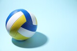 Colorful volleyball ball on light blue background. Space for text
