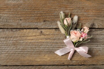 Wall Mural - Boutonnieres with beautiful flowers on wooden background, flat lay. Space for text