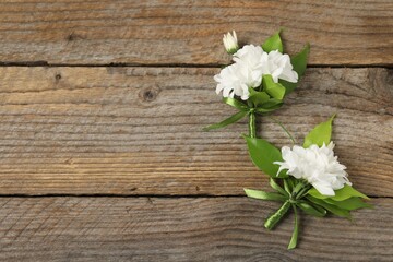 Wall Mural - Boutonnieres with beautiful flowers on wooden background, flat lay. Space for text