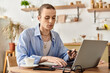 © Bliss - Young man in casual attire works focused at a cafe table during a sunny afternoon