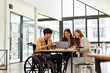 © David - Asian Male Manager On A Wheelchair Sitting With His Colleagues At Workplace