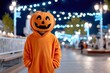 © Moopingz - A child in a festive pumpkin costume stands outdoors at night, surrounded by bright bokeh lights.