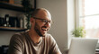 © ekhtiar - Joyful man laughing heartily while working on laptop, embracing modern remote work lifestyle with a smile