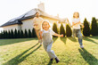 © Maria Vitkovska - Happy family running in the garden of their house with solar panels