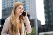 © NT_studio - Young caucasian businesswoman happy talk on smartphone outdoors, happiness business female using smart phone in urban, communication and success with telecommuting, business woman speaking on phone.