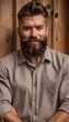 © ALK - Stylish bearded man with confident smile, posed on the left against wooden background, ample blank space on right for branding.