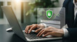 © Shutter Wisp - Business professional using laptop with digital security shield and login screen overlay