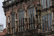 Ventanas góticas en la fachada de piedra desgastada del Ayuntamiento de Bremen, Alemania. Detalle de la arquitectura y la textura de un monumento histórico.