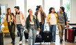 © Davide Angelini - Young group of tourists with suitcases arriving at youth hostel guest house - Happy friends enjoying summer vacation together - Millenial people doing check-in at hotel lobby - Summertime holidays