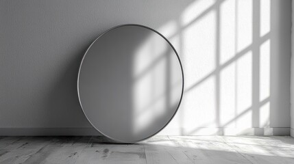 A round mirror with a metallic frame reflecting a window with sunlight streaming in.