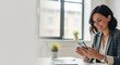 © ProArt Studios - Happy female entrepreneur focused on her smartphone, smiling whi
