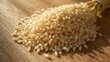 © Payukrti - A pile of fresh brown rice grains, a staple food crop, on a wooden surface