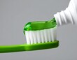 © Bapuq - Green toothpaste being squeezed onto a toothbrush