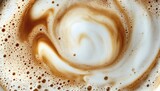 The image shows a detailed close-up of a coffee drink's frothy surface, featuring a blend of white foam and brown coffee swirls.