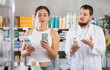 © JackF - Young woman buyer choosing box of pills with help of young man pharmacist in pharmacy