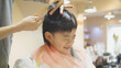 © folyphoto - 美容室で散髪を受ける5歳の男の子