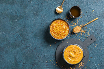 Wall Mural - Bowl with Dijon mustard and sweet honey on dark background