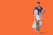 © Pixel-Shot - Male student with tablet computer and backpack on orange background