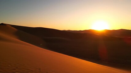 Wall Mural - Desert sunrise timelapse showcasing shifting shadows and golden light on sand dunes nature, wilderness, expansive