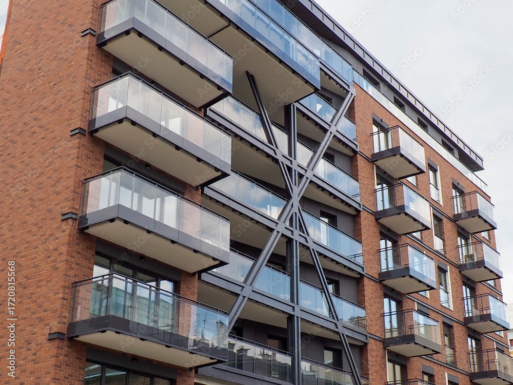 A large modern apartment building with multiple balconies and a large colorful mural on one side of its facade.